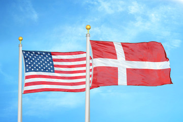 United States and Denmark two flags on flagpoles and blue cloudy sky