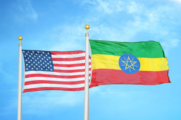 United States and Ethiopia two flags on flagpoles and blue cloudy sky