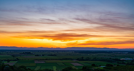 Sunset over fields; Orange sky, cloulds and fields