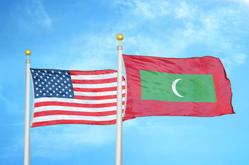United States and Maldives two flags on flagpoles and blue cloudy sky