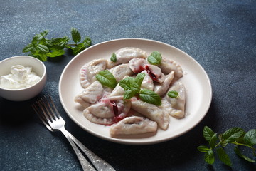 Dumplings with cherries,sour cream and mint. Ukrainian, Russian and Belarusian cuisine. Healthy breakfast