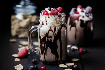 Oreo milkshake on dark background with berries on top