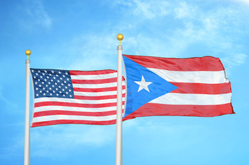 United States and Puerto Rico two flags on flagpoles and blue cloudy sky