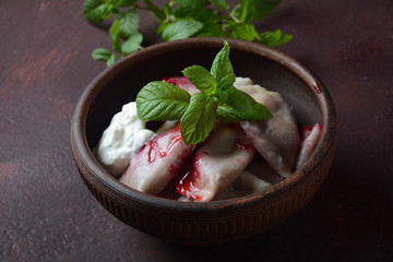 Dumplings with cherries,sour cream and mint. Ukrainian, Russian and Belarusian cuisine. Healthy breakfast