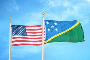 United States and Solomon Islands two flags on flagpoles and blue cloudy sky