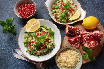 Healthy salad with couscous, fresh mint, cucumber, pomegranate, lemon and olive oil. Eastern cuisine. Vegan food concept. Traditional Israeli food