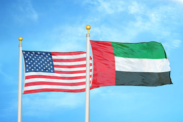 United States and United Arab Emirates two flags on flagpoles and blue cloudy sky