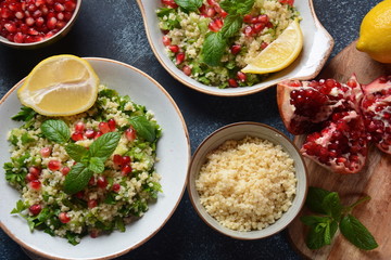 Healthy salad with couscous, fresh mint, cucumber, pomegranate, lemon and olive oil. Eastern cuisine. Vegan food concept. Traditional Israeli food