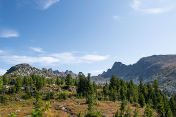 rocky ridge under blue sky in mountain valley, journey of climbers on sheer cliffs