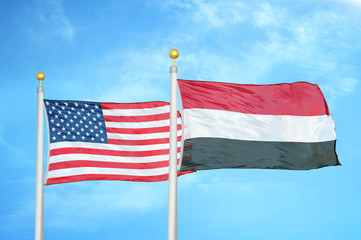 United States and Yemen two flags on flagpoles and blue cloudy sky