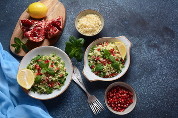 Healthy salad with couscous, fresh mint, cucumber, pomegranate, lemon and olive oil. Eastern cuisine. Vegan food concept. Traditional Israeli food