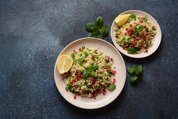 Healthy salad with couscous, fresh mint, cucumber, pomegranate, lemon and olive oil. Eastern cuisine. Vegan food concept. Traditional Israeli food