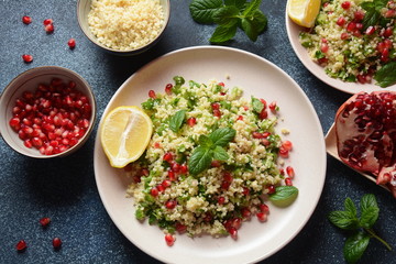 Healthy salad with couscous, fresh mint, cucumber, pomegranate, lemon and olive oil. Eastern cuisine. Vegan food concept. Traditional Israeli food