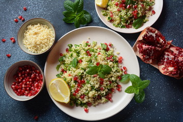 Healthy salad with couscous, fresh mint, cucumber, pomegranate, lemon and olive oil. Eastern cuisine. Vegan food concept. Traditional Israeli food