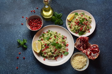 Healthy salad with couscous, fresh mint, cucumber, pomegranate, lemon and olive oil. Eastern cuisine. Vegan food concept. Traditional Israeli food