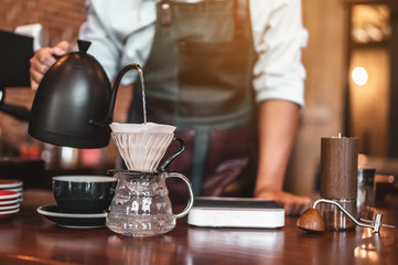 Close-up coffee maker that is professionally extracting coffee by barista with a deep white glass...