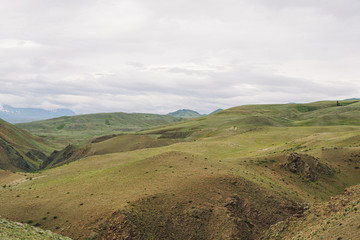 Fototapeta premium gentle red hills, journey through mountain valley, pastures for animals, soil erosion in arid steppe