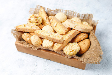 Various cookies in a wooden tray on gray background