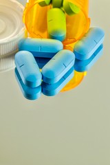 large blue antiviral pills with prescription bottle and copy space