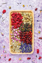 Assortment of dry tea in golden vintage mini plates.Tea types background:hibiscus,chamomile,mixed black tea,dry roses,butterfly pea tea
