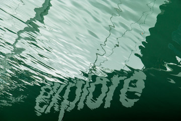 Word Explore reflected in the water against green liquid background