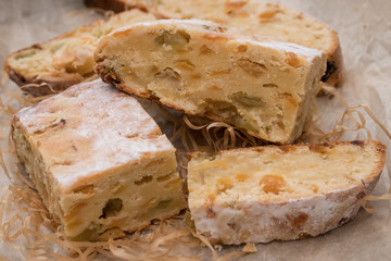 Sliced pieces of homemade pie with candied fruit and raisins (stollen) lie on the table