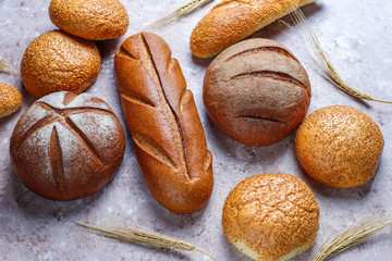 Different kinds of fresh bread as background, top view