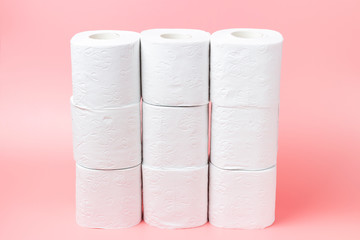 A stack of white rolls in toilet paper on a pink background close up, purchasing concert