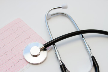 Stethoscope and ECG cardiogram on white background
