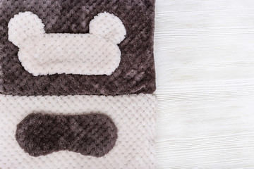 Soft fluffy pillow and sleep mask for eye on white background. Top  view. Flat lay.