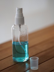 Alcoholic 70 percent in clear bottle on the wooden desk for spray washing clean dirty kill to prevent germs protect colona virus, covid 19