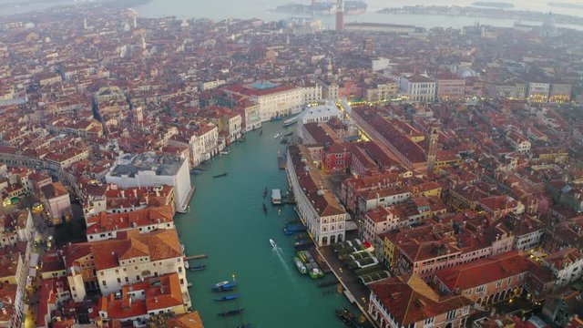 Aerial, tilt up, drone shot over the canal Grande, misty sunset, in Venice city, Italy