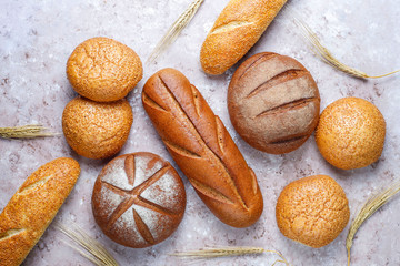 Different kinds of fresh bread as background, top view