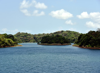 Fototapeta na wymiar Green landscape of Panama Canal, view from the transiting cargo ship.