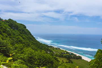 Fototapeta na wymiar The beautiful nature of Indonesia and the island of Bali. Slopes and cliffs overlooking the waves of the blue ocean. Tropical and exotic view of travel to Asia