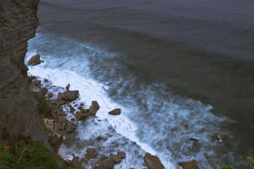 The beautiful nature of Indonesia and the island of Bali. Slopes and cliffs overlooking the waves of the blue ocean. Tropical and exotic view of travel to Asia