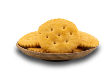 Pile of crunchy round crackers in wooden plate on white background with clipping path.