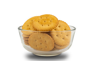 Pile of round crackers in glass bowl on white background with clipping path