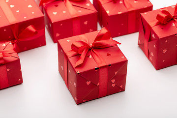 Boxes with gifts in red paper decorated with ribbons with bows. White background, copy space.