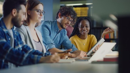 University Library: Diverse Group of Gifted Students Have Discussion, use Laptop, Prepare for Exams Together, Helping, Researching Subjects for Paper Assignment. Happy Young People Study for Future
