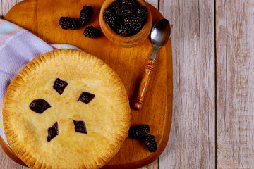 Homemade pie filling with blackberries on wooden background. Top view.