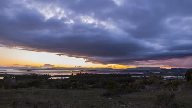 Sunset behind the clouds with rain clouds rolling in over the American Canyon wetlands