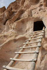 Close-up of ladder leading up to ancient cliff dwelling entrance at Bandelier National Monument in New Mexico desert