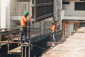 Workers are working on construction site, labourers wearing vest and safety helmet, construction...