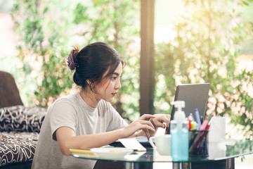 Coronavirus. Business woman working from home. Asian woman in quarantine for protective coronavirus. Cleaning her hands with sanitizer gel. Asian woman student leaning online at home.