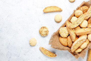 Various cookies in a wooden tray on gray background