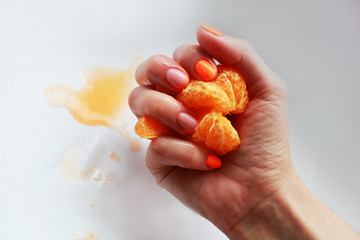 female hand with bright manicure holds a mandarin