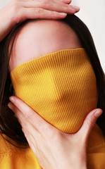 woman hides her face behind a cloth