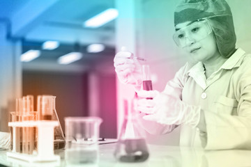 Asian Scientist Pipetting at a Biomedical Laboratory.Focused young life science professional pipetting solution into the glass cuvette. Lens focus