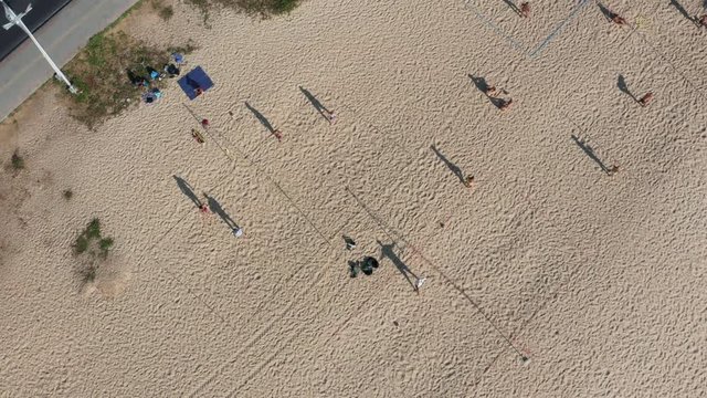 Top view of people playing beach volleyball at the playground near the roadside at Karon beach in the afternoon, Phuket,  Thailand.